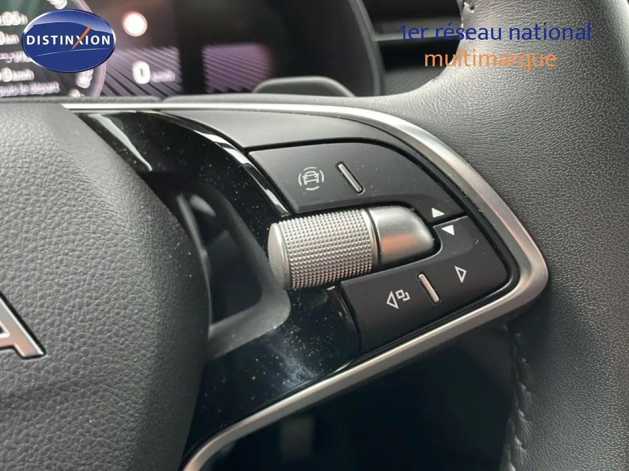 Gros plan sur les commandes multifonctions au volant noir du Skoda Kamiq blanc Glacier 2025, version Selection.