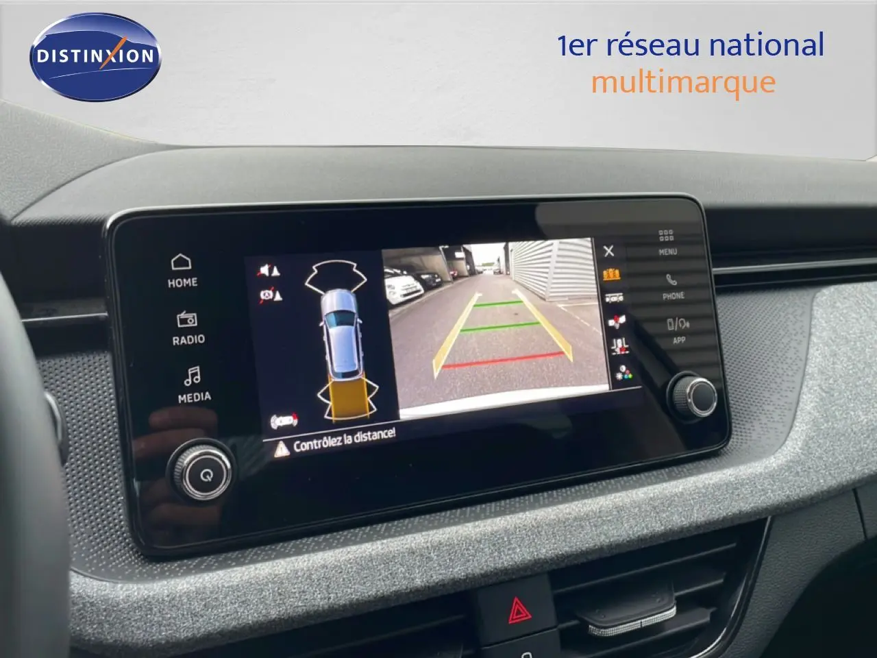 Écran central du Skoda Kamiq blanc glacier 2025 affichant la caméra de recul avec guidage de trajectoire.