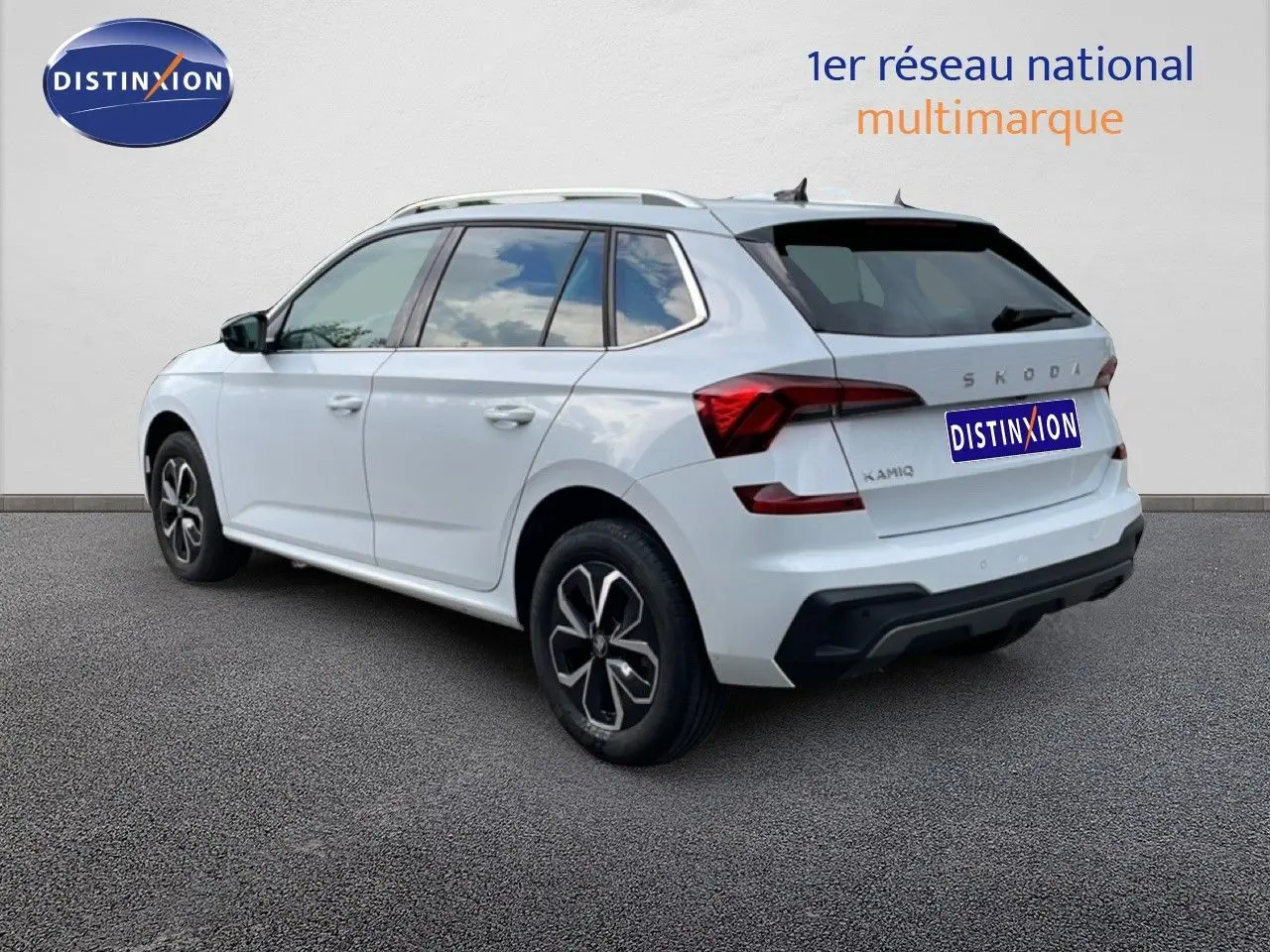 Vue 3/4 arrière droite d'un Skoda Kamiq blanc glacier 2025 avec jantes alliage et feux arrière LED distinctifs.