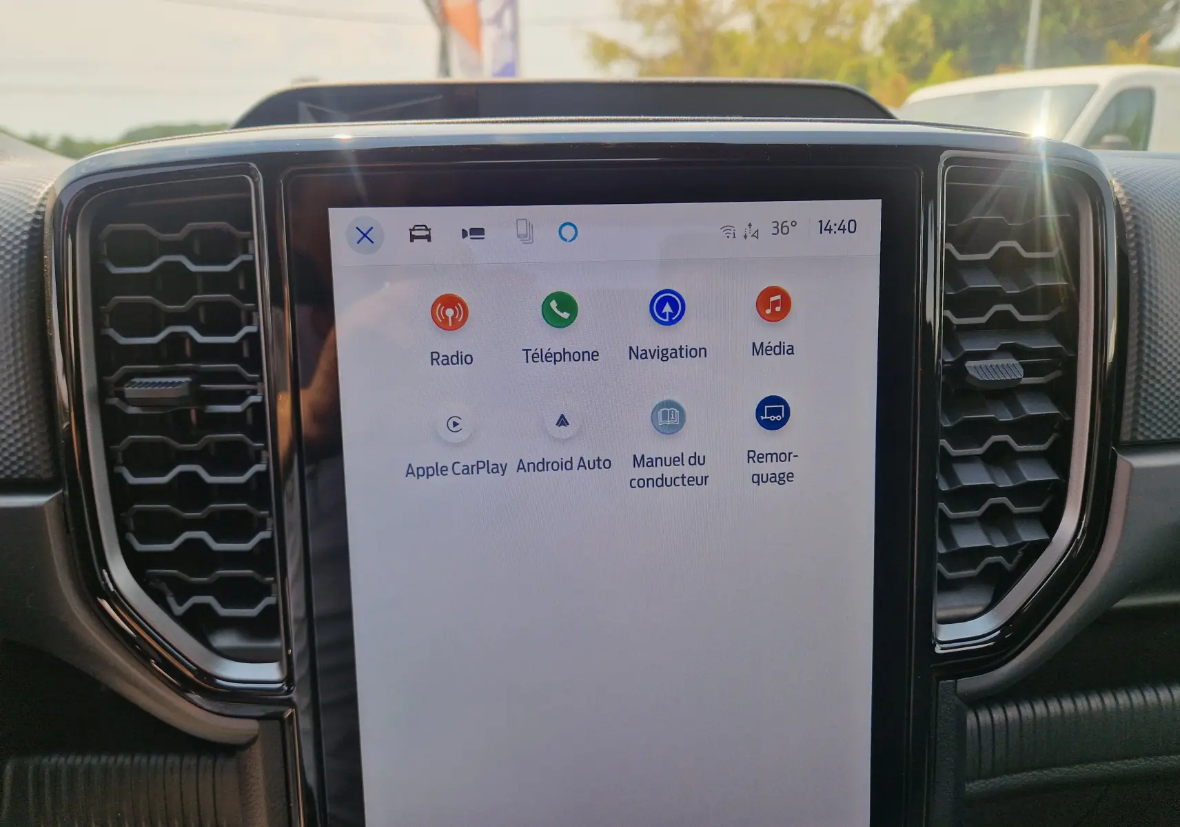 Écran tactile central du Ford Ranger Super Cabine blanc, affichant le menu principal avec options multimédia et navigation.