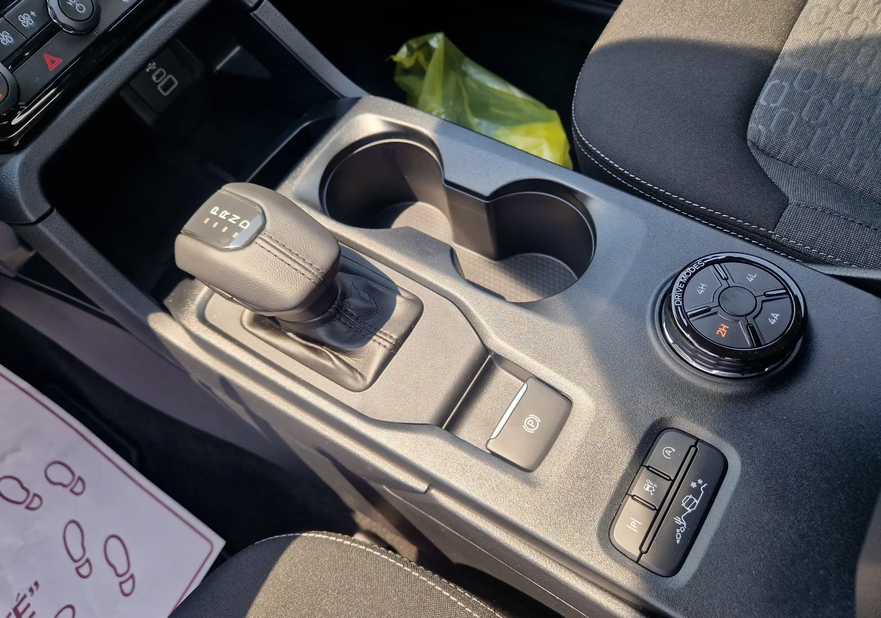Gros plan sur la console centrale du Ford Ranger Super Cabine blanc, montrant levier de vitesses et sélecteur de modes 4x4.