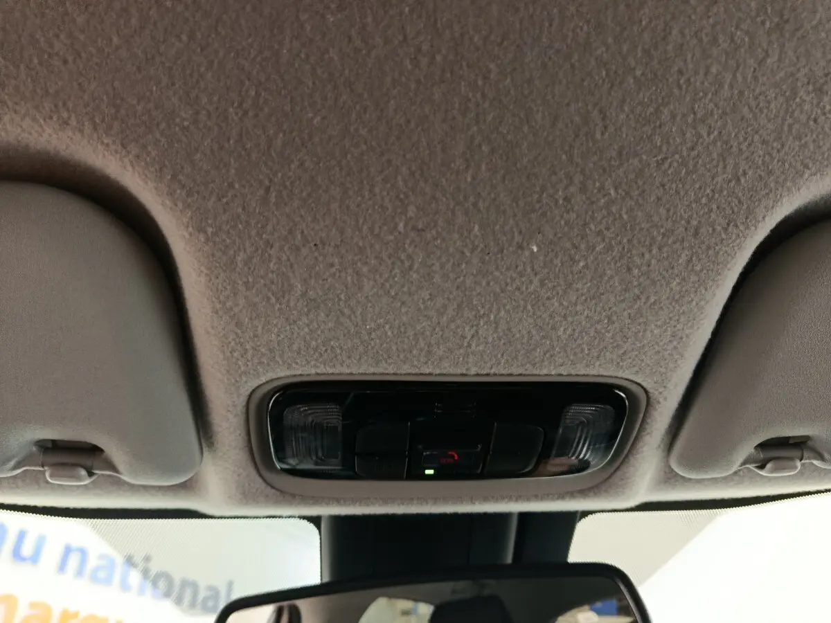 Vue intérieure du plafonnier et rétroviseur central de la Toyota Yaris hybride gris clair 2023.