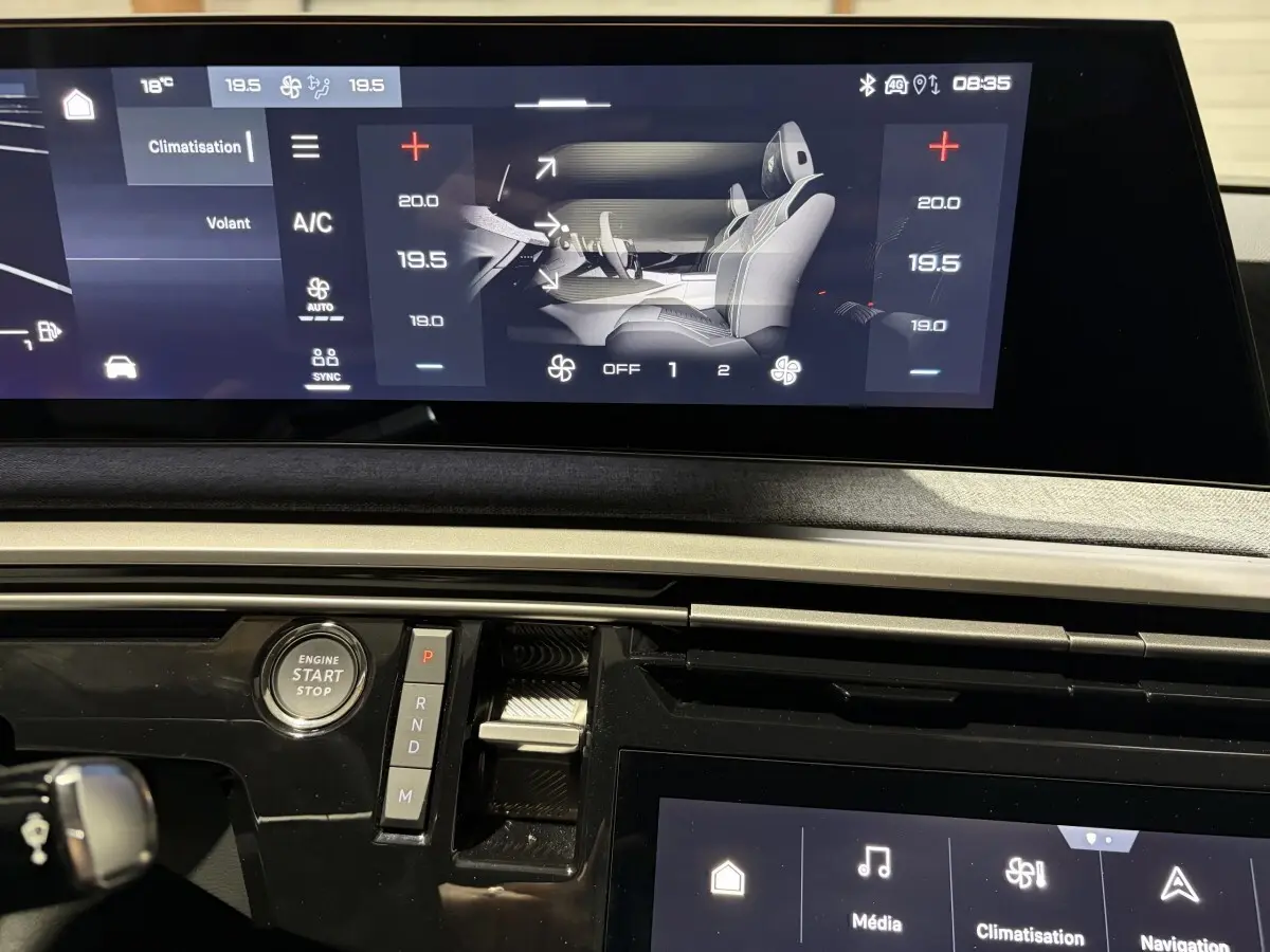 Vue rapprochée du tableau de bord du Peugeot 3008 blanc 2026 avec écran tactile et bouton démarrage visible.