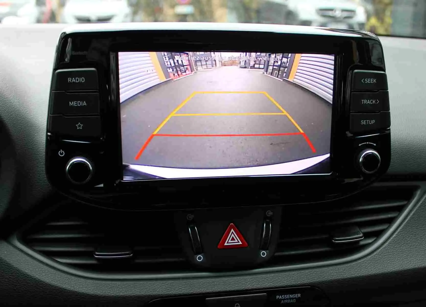 Écran central de la Hyundai i30 SW 2022 montrant la caméra de recul avec lignes de guidage colorées.
