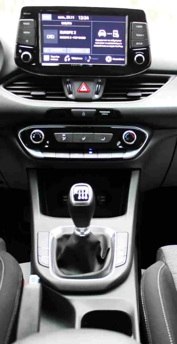 Intérieur de la Hyundai i30 SW 2022 montrant la console centrale avec levier de vitesse manuel et écran tactile.