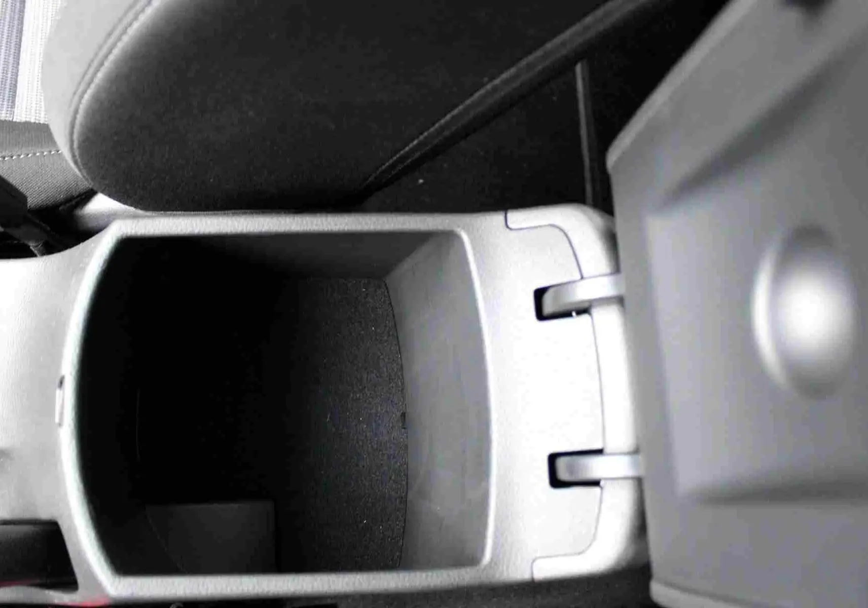 Gros plan sur le rangement central ouvert de la Hyundai i30 SW 2022, intérieur en tissu gris noir.