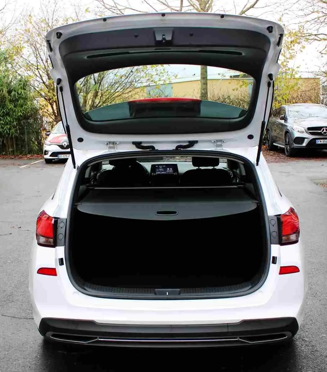 Vue arrière d'une Hyundai i30 SW blanche polaire 2022 avec coffre ouvert et intérieur visible.