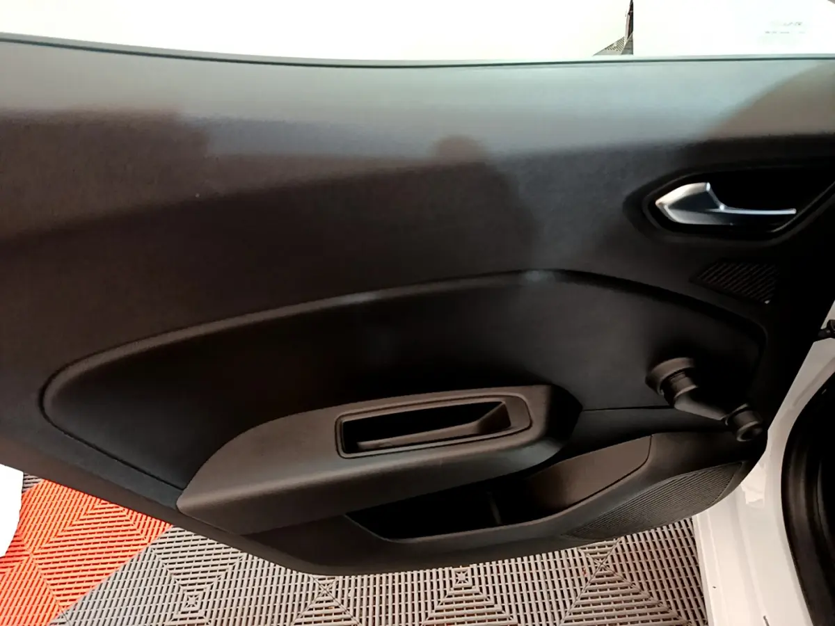 Vue rapprochée de la porte intérieure côté droit de la Renault Clio Business TCe 100 blanche, avec poignée et manivelle de vitre.