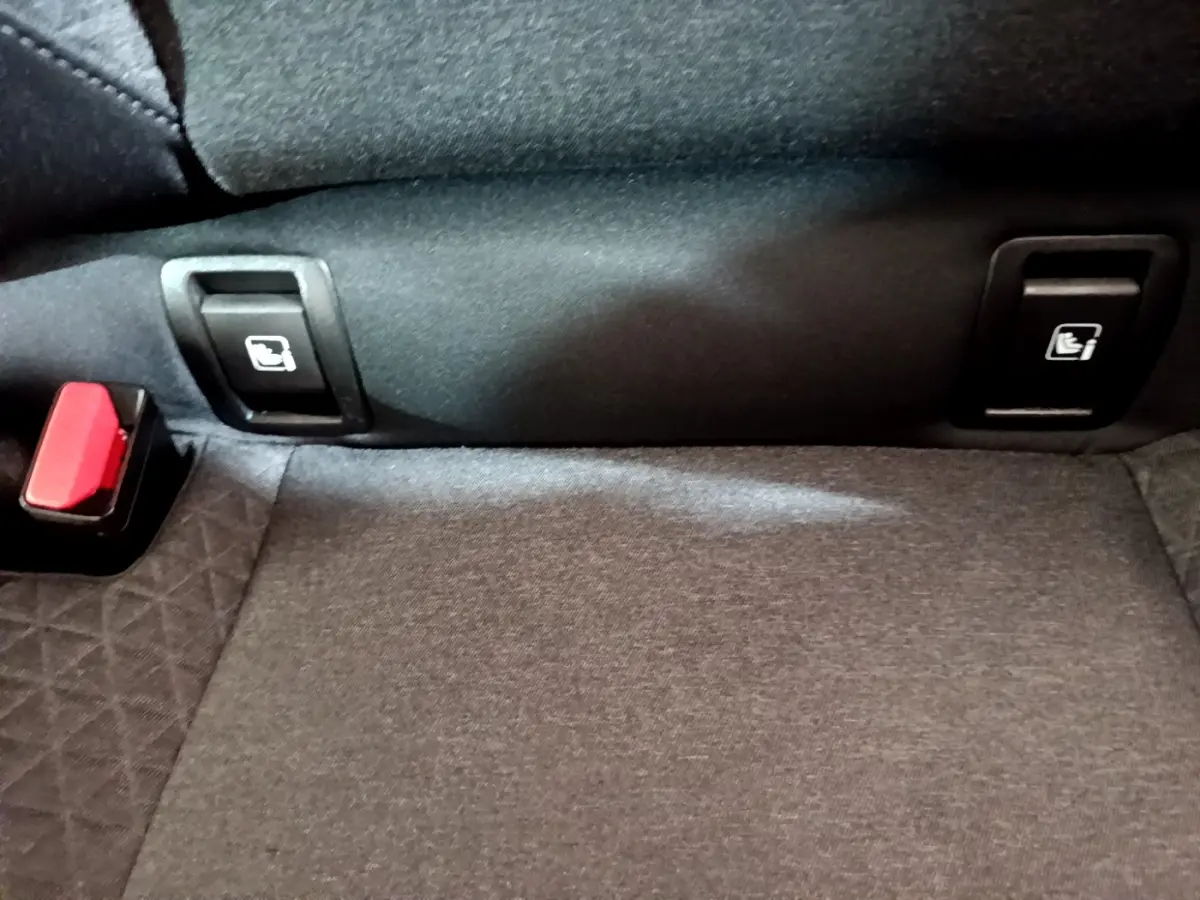 Gros plan sur la banquette arrière noire de la Renault Clio Business TCe 100, montrant les commandes de rabattement des sièges.