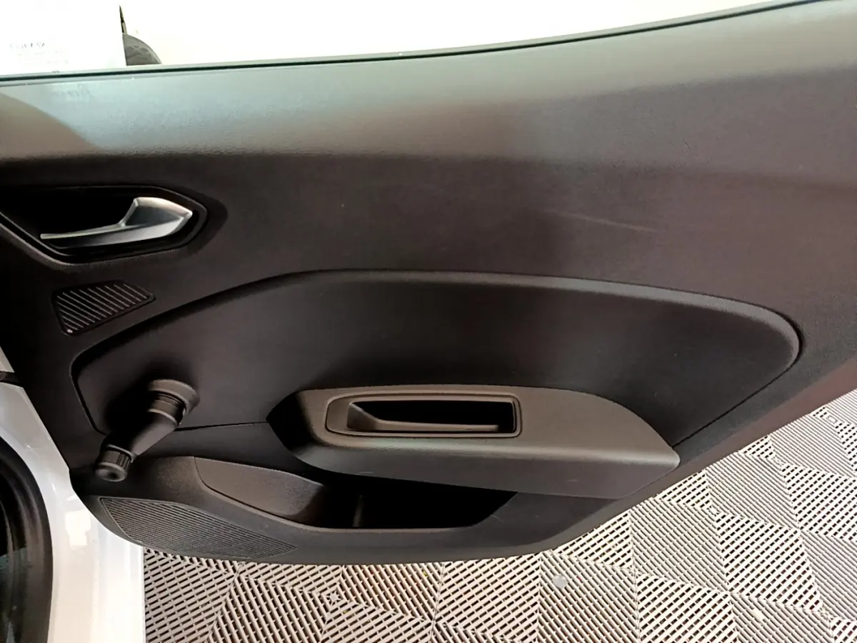 Vue rapprochée de la porte intérieure côté gauche d'une Renault Clio Business TCe 100 blanche, avec poignée et manivelle de vitre.