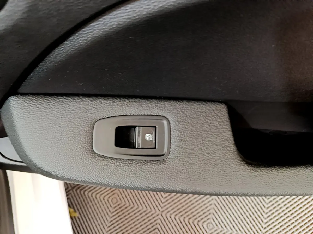 Bouton de commande de vitre électrique sur la porte intérieure côté gauche d'une Renault Clio blanche de 2020.