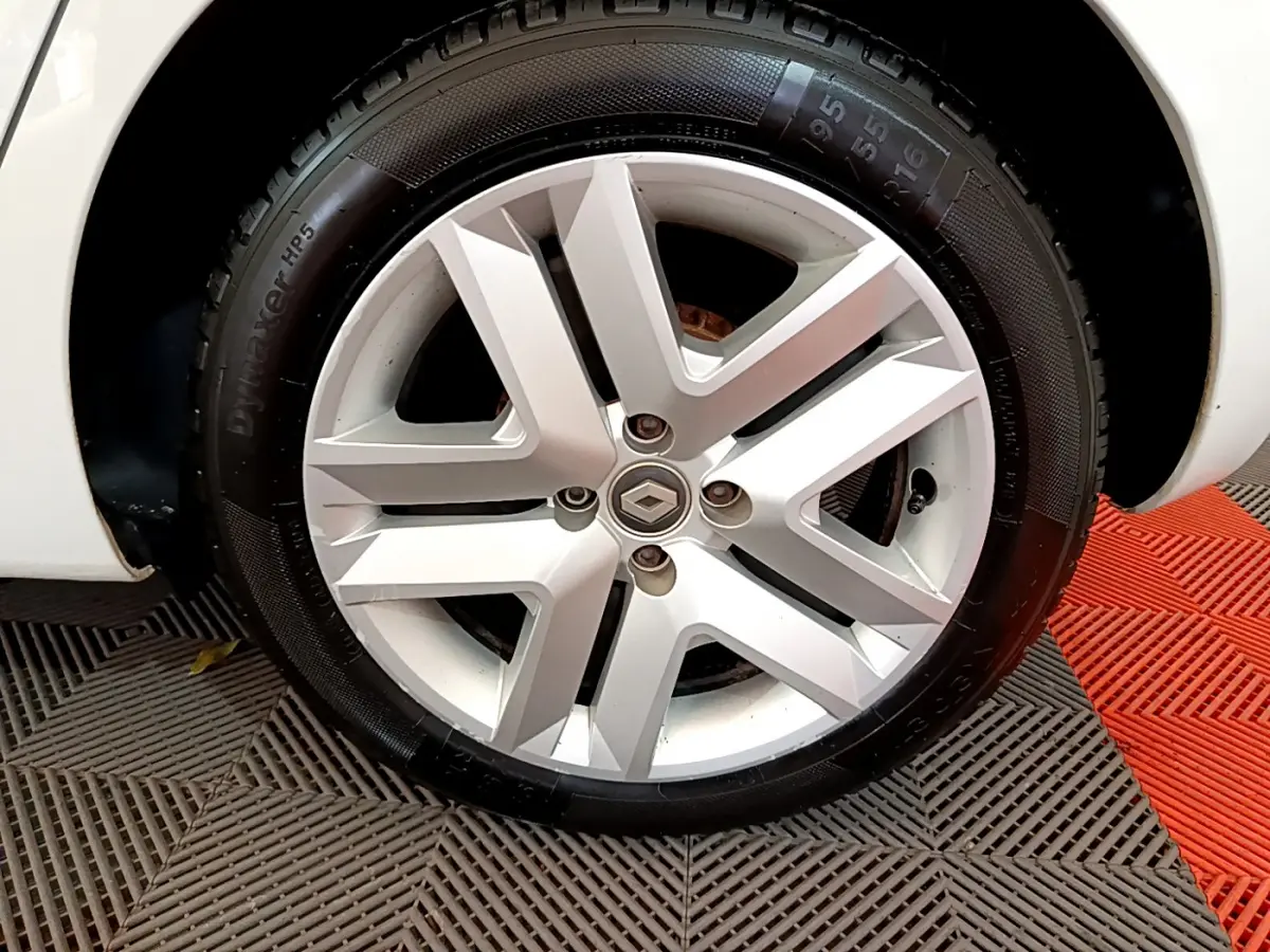 Gros plan sur la roue avant gauche blanche d'une Renault Clio Business TCe 100 avec jante alliage distinctive.