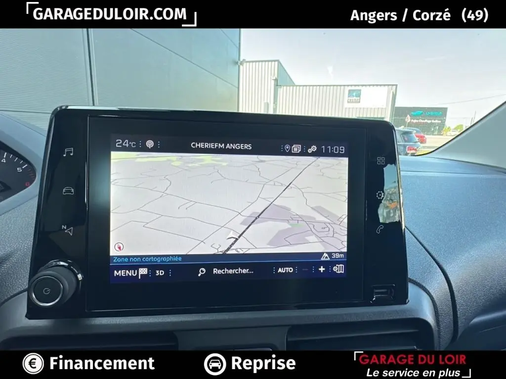 Vue intérieure du tableau de bord du Peugeot Rifter 2024 avec écran tactile de navigation allumé.