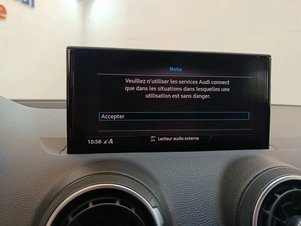 Écran tactile central affichant un message d’avertissement dans l’habitacle d’un Audi Q2 gris foncé.