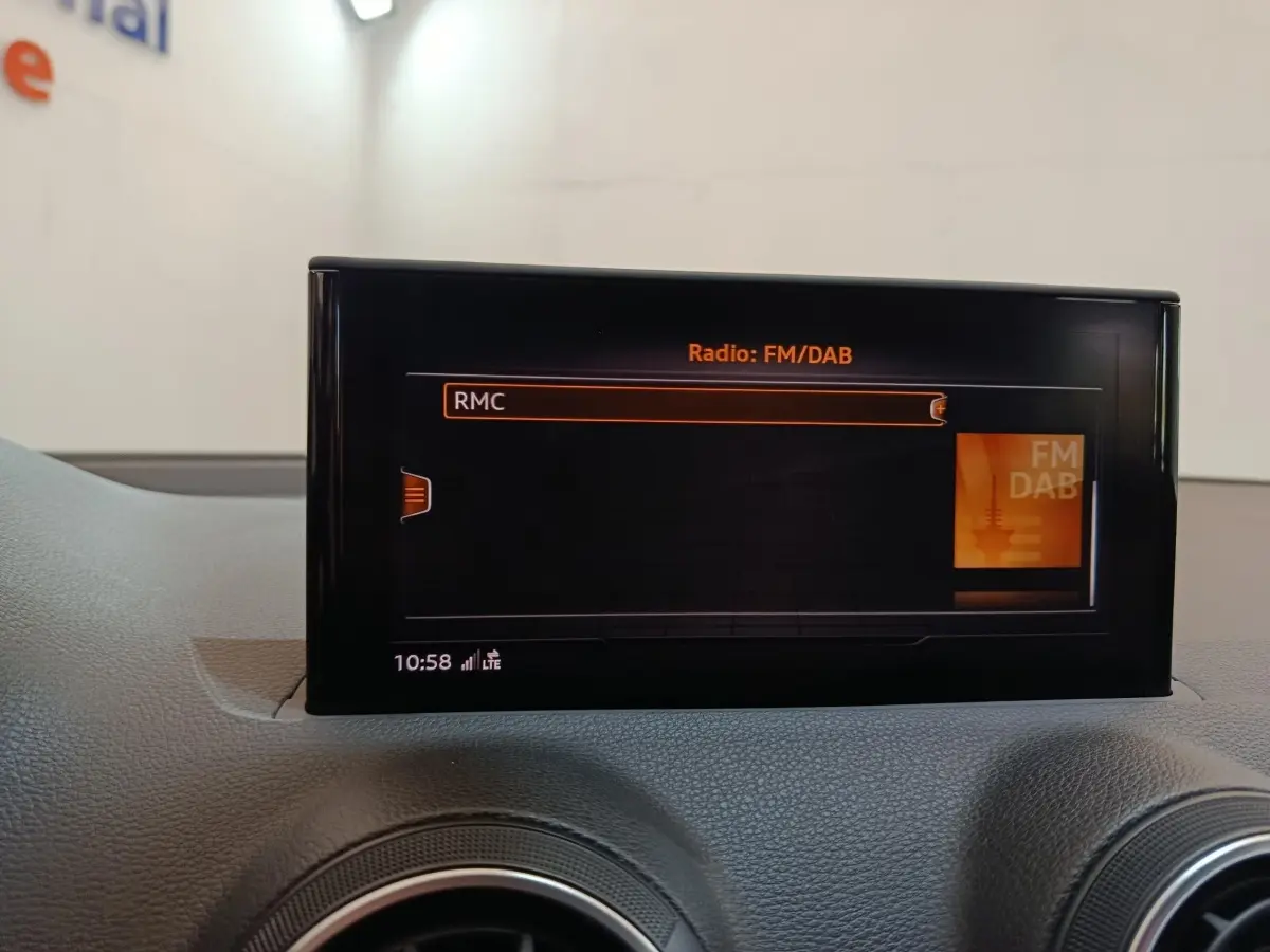 Écran tactile central affichant la radio FM/DAB dans l'habitacle gris foncé de l'Audi Q2 35 TFSI Business Line.