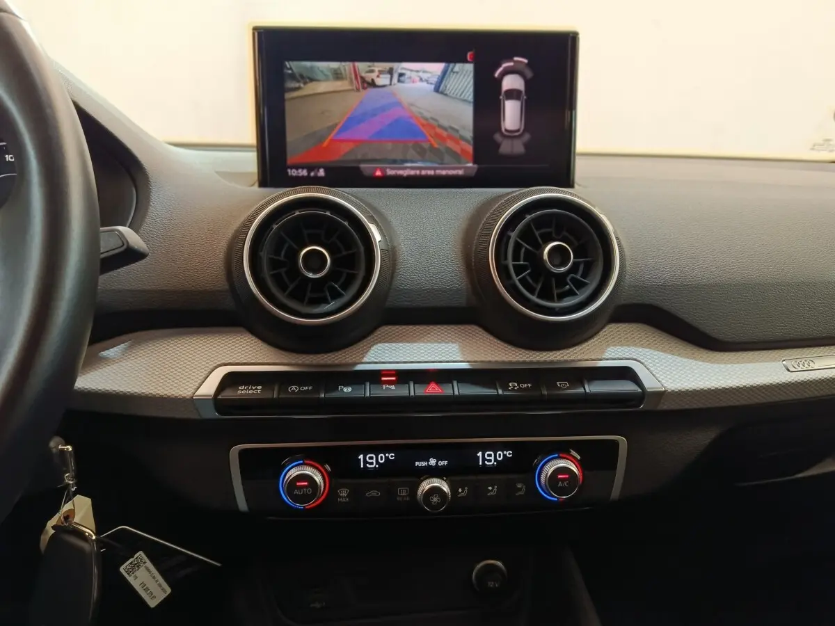 Vue intérieure du tableau de bord de l'Audi Q2 gris foncé, avec écran tactile affichant la caméra de recul.
