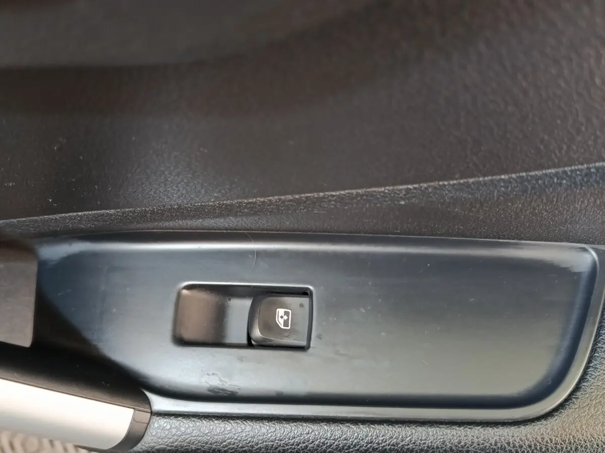 Gros plan sur l'interrupteur de commande de lève-vitre côté conducteur de l'Audi Q2 gris foncé 2022.