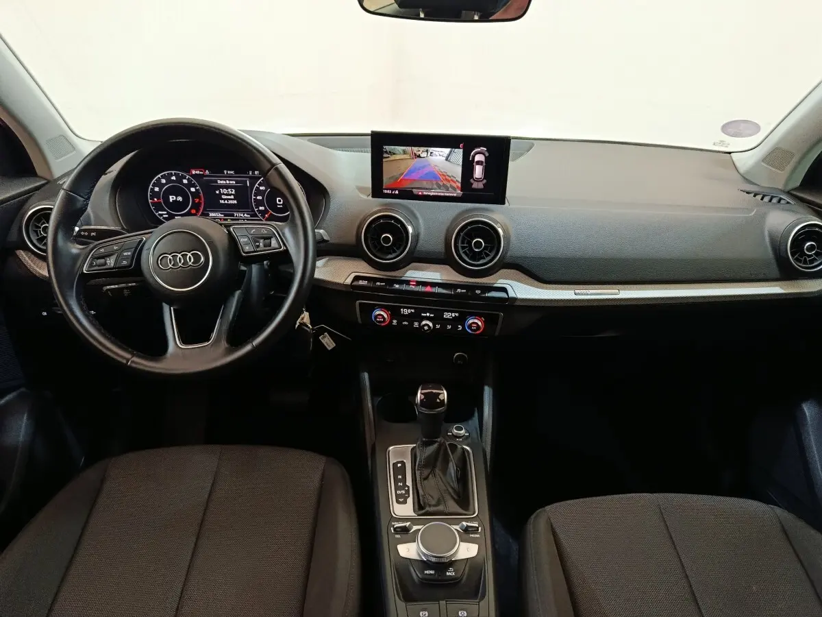Vue intérieure frontale de l'Audi Q2 35 TFSI 150 S Tronic Business Line 2022, tableau de bord noir avec écran tactile central.
