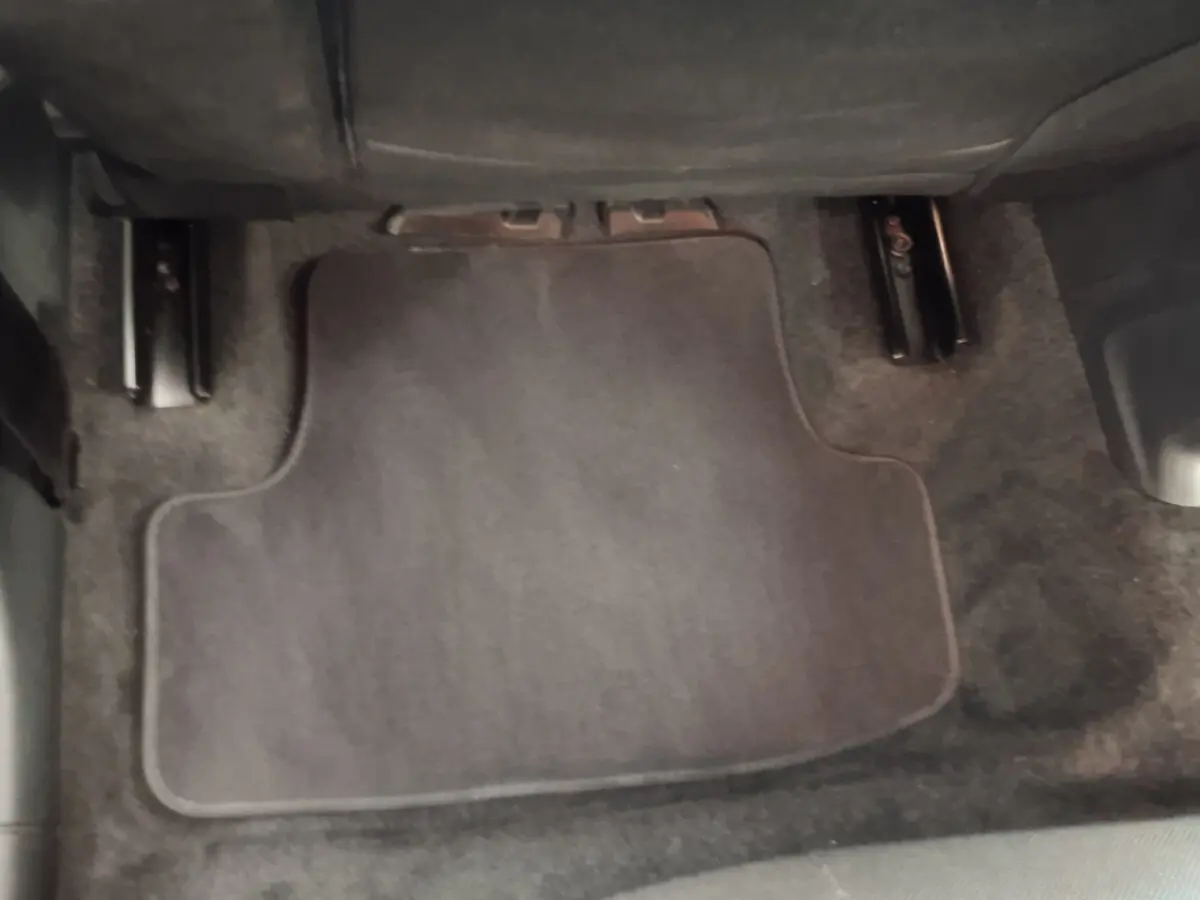 Plancher côté passager avec tapis de sol gris foncé dans un Audi Q2 35 TFSI 2022, vue rapprochée intérieure.