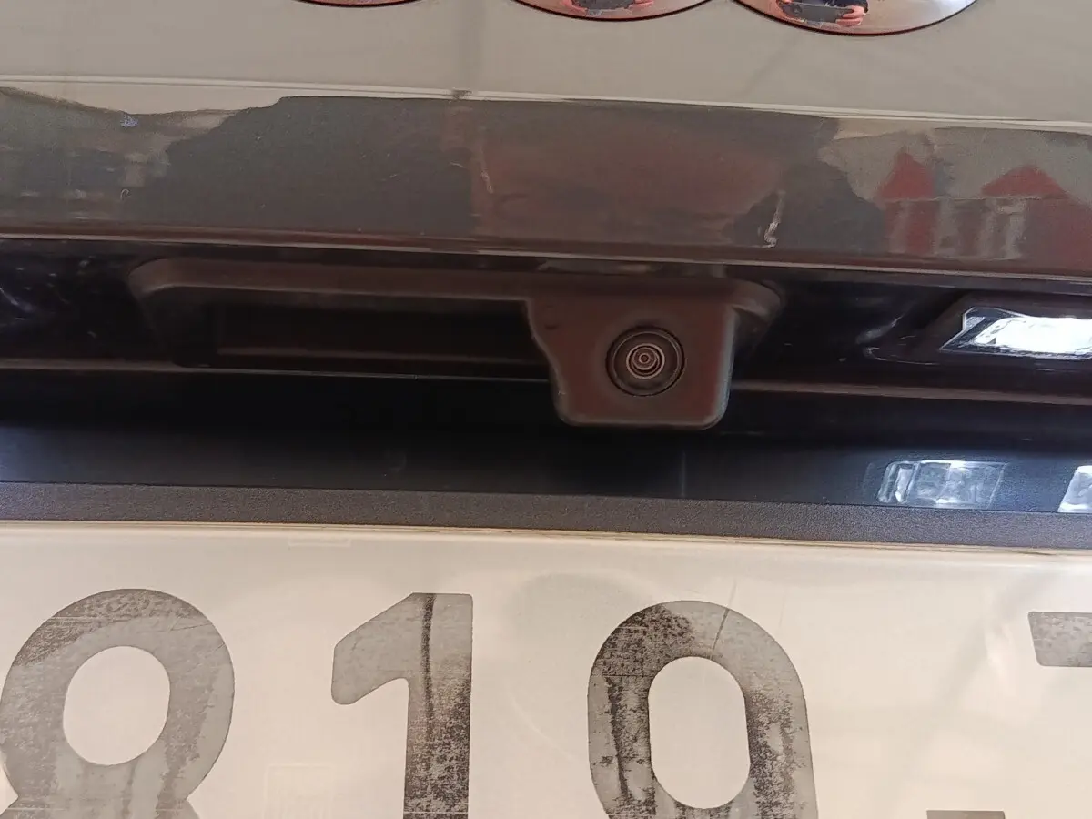 Gros plan sur la caméra de recul et l’éclairage de plaque arrière d’un Audi Q2 gris foncé.