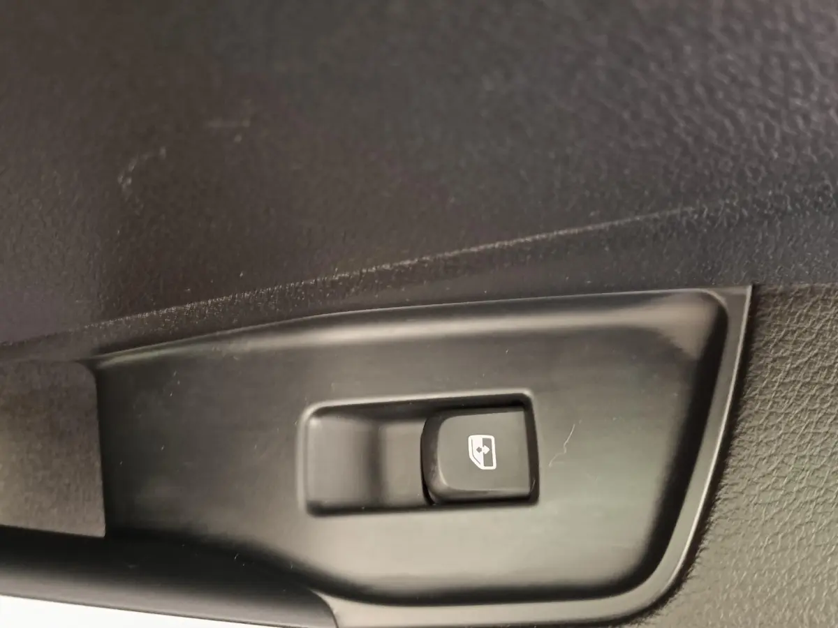 Gros plan sur le bouton de commande de la ventilation additionnelle siège passager dans un Audi Q2 gris foncé 2022.