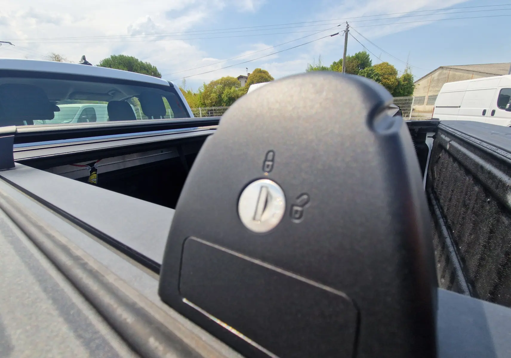 Détail du verrouillage du rideau de plateau rigide sur Ford Ranger Super Cabine blanc, vue arrière côté droit.