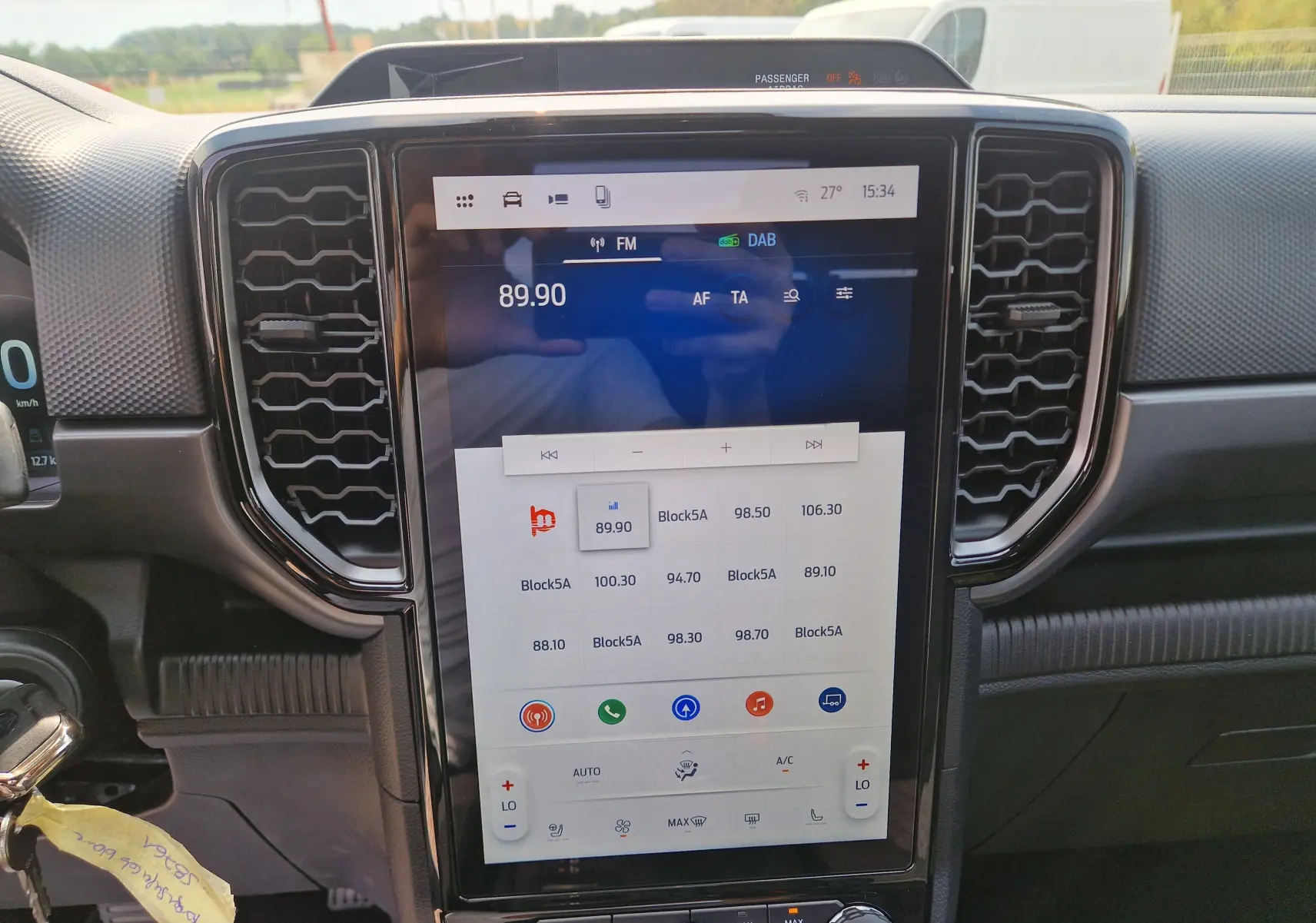 Vue rapprochée de l’écran tactile central 12,4 pouces du Ford Ranger Super Cabine blanc, avec commandes climatisation et audio visibles.