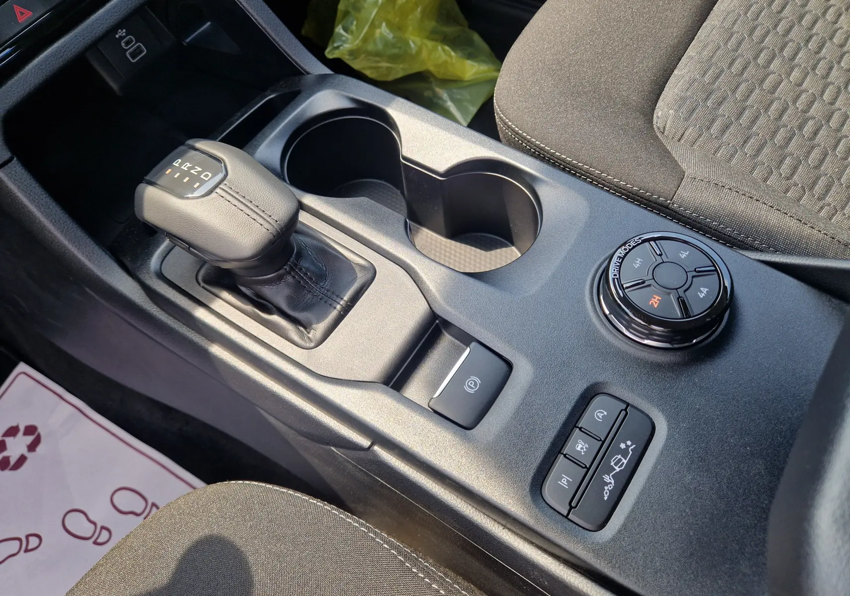 Vue rapprochée de la console centrale du Ford Ranger blanc, avec levier de boîte auto et sélecteur modes de conduite.