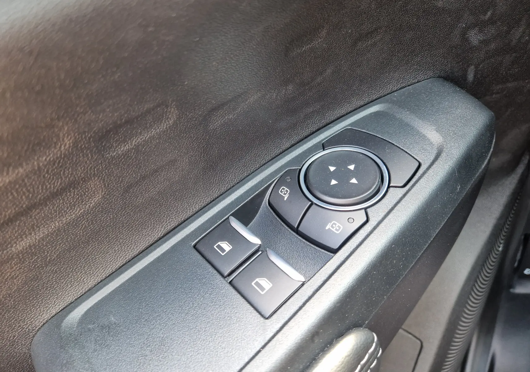 Détail des commandes électriques des vitres et rétroviseurs sur la porte intérieure noire du Ford Ranger Super Cabine blanc.
