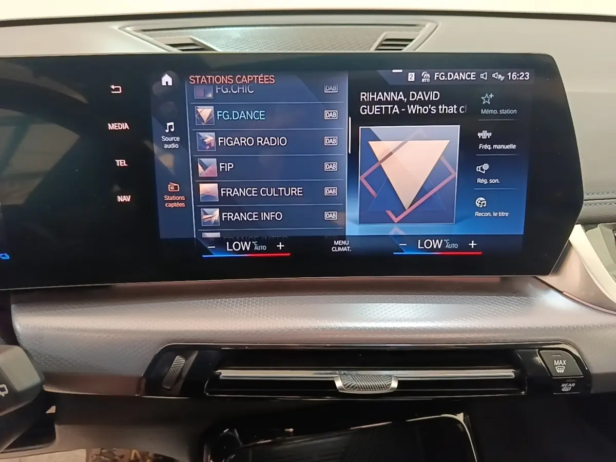 Écran tactile central du tableau de bord de BMW X1 xDrive25e M Sport gris foncé, affichant menu radio et climatisation.