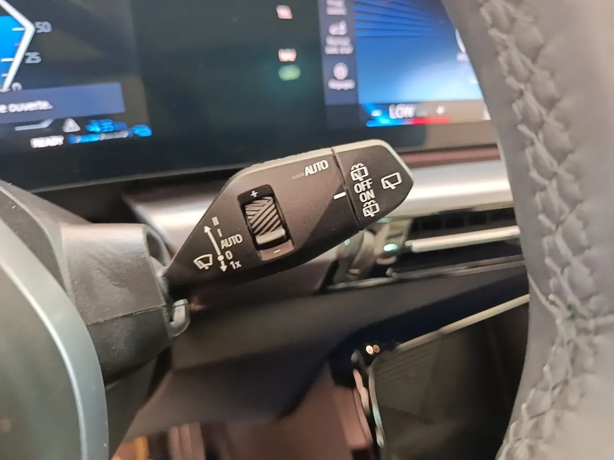 Gros plan sur la commande d’essuie-glace à gauche du volant en cuir gris d’un BMW X1 xDrive25e M Sport 2023.