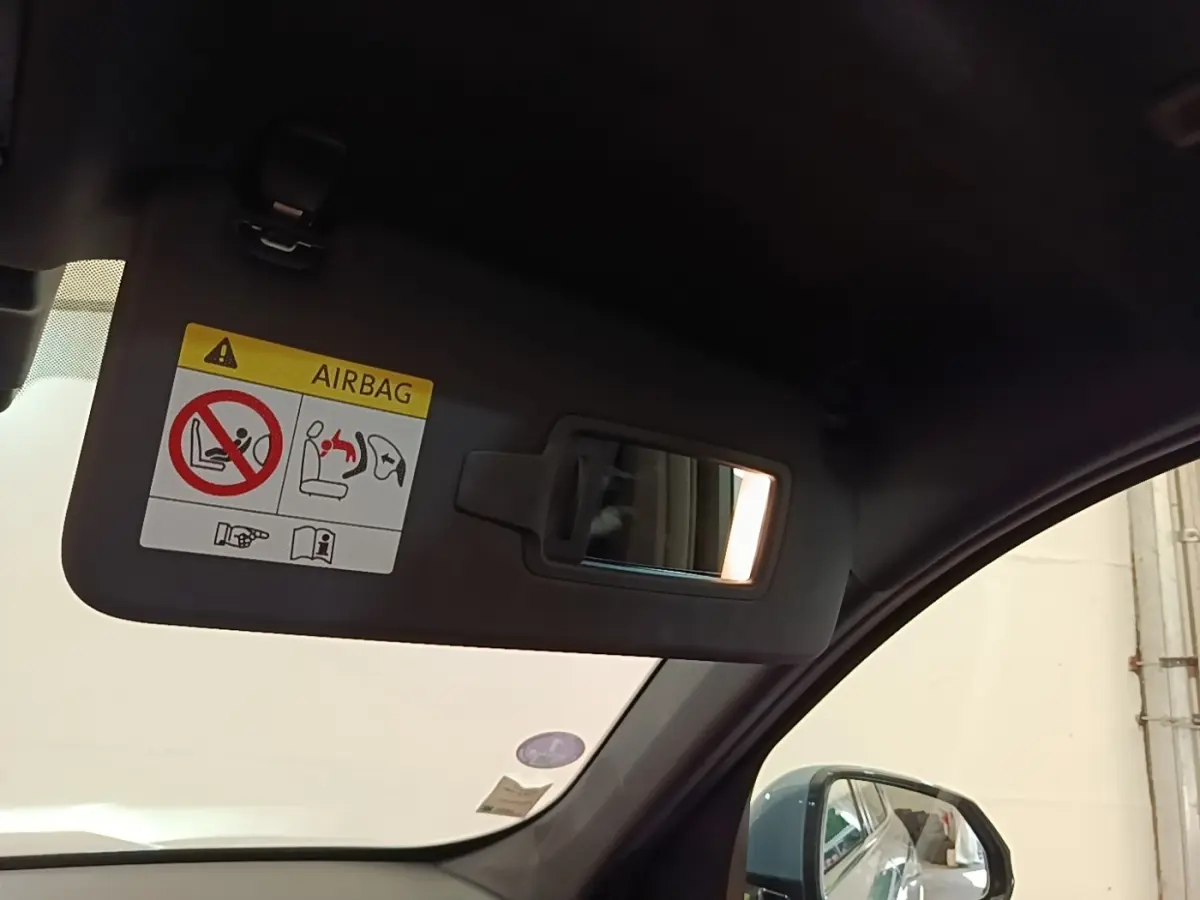 Intérieur BMW X1 xDrive25e M Sport 2023, vue côté droit sur pare-soleil gris avec miroir et rétroviseur extérieur gris foncé.