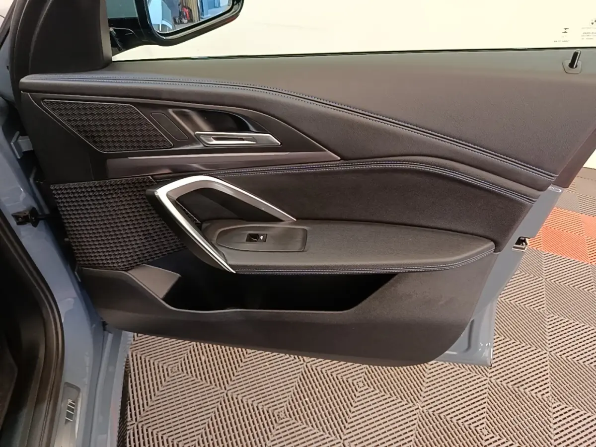 Vue intérieure de la porte avant gauche d’un BMW X1 xDrive25e M Sport 2023, garniture noire avec insert alu.