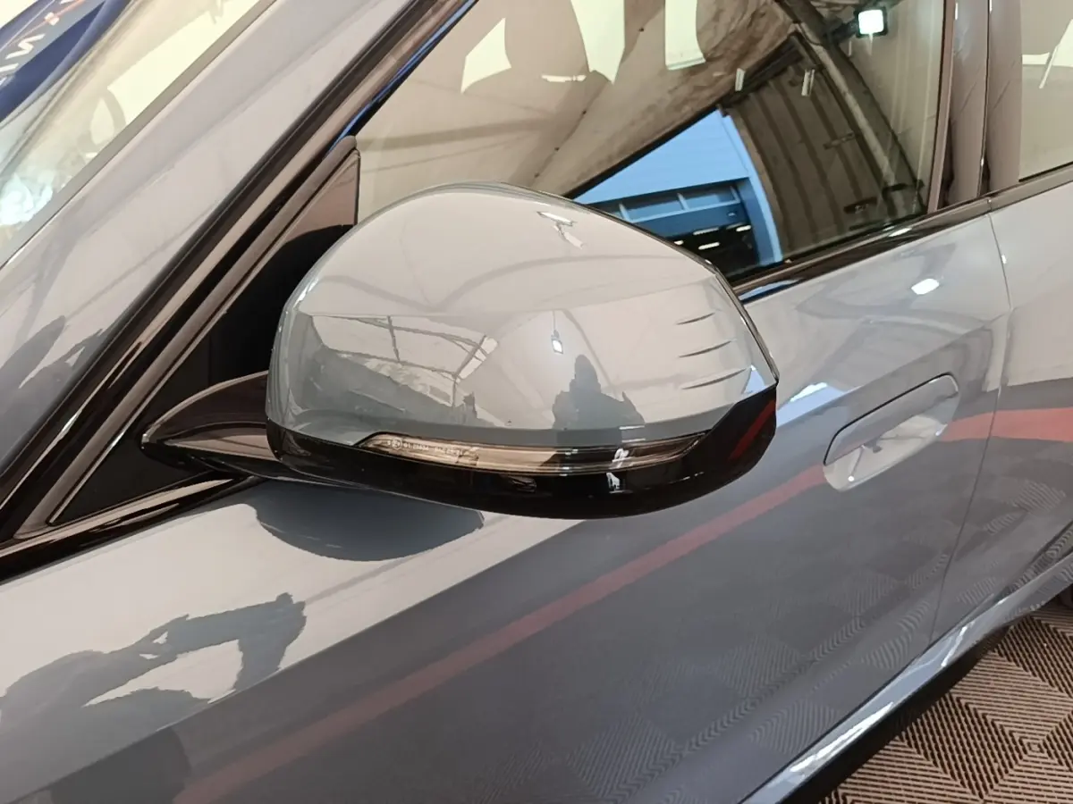 Rétroviseur côté conducteur gris foncé avec clignotant intégré sur BMW X1 xDrive25e M Sport 2023, vue latérale rapprochée.