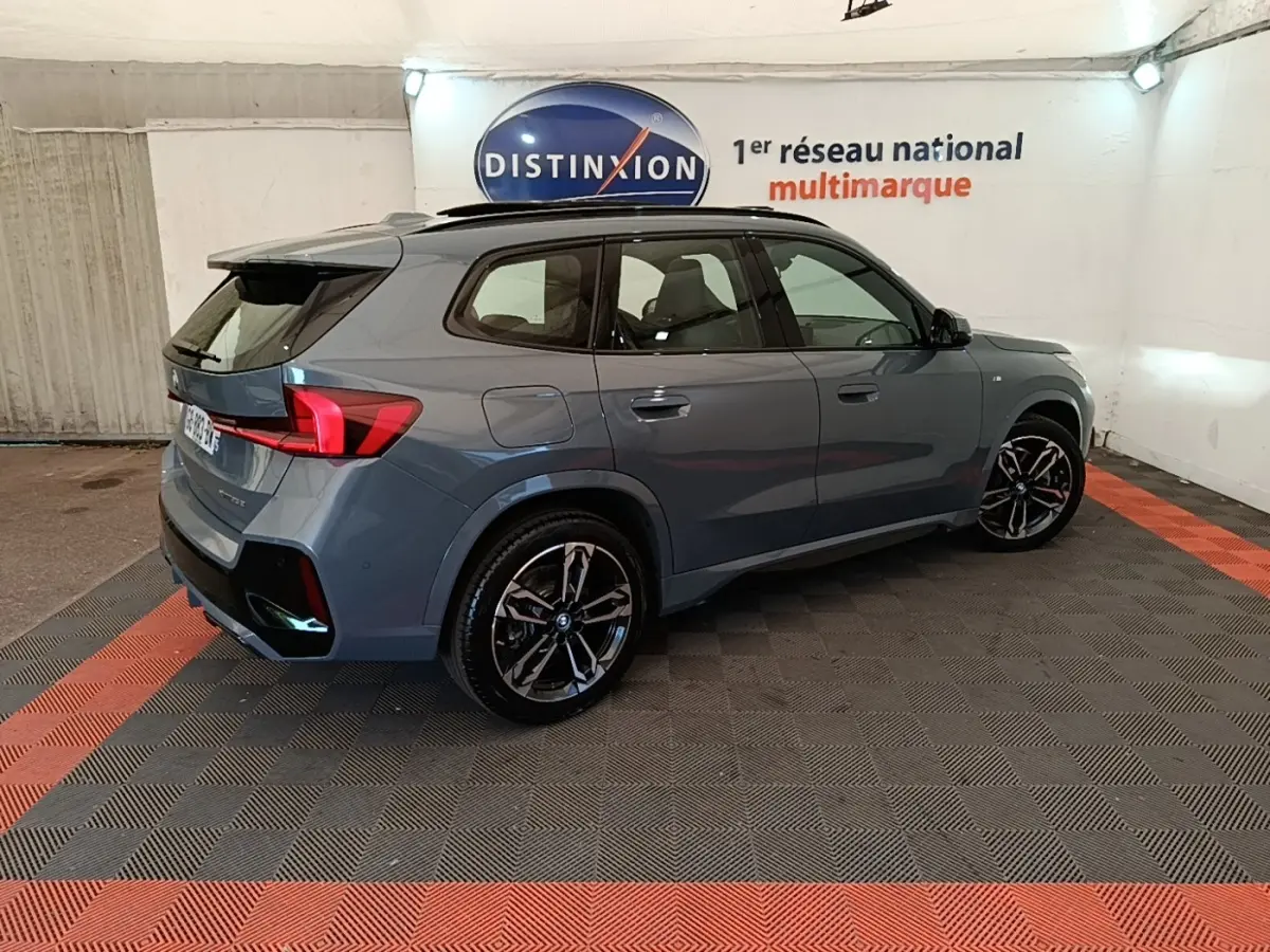 BMW X1 xDrive25e M Sport gris foncé vue 3/4 arrière droit, avec jantes noires et toit ouvrant panoramique.