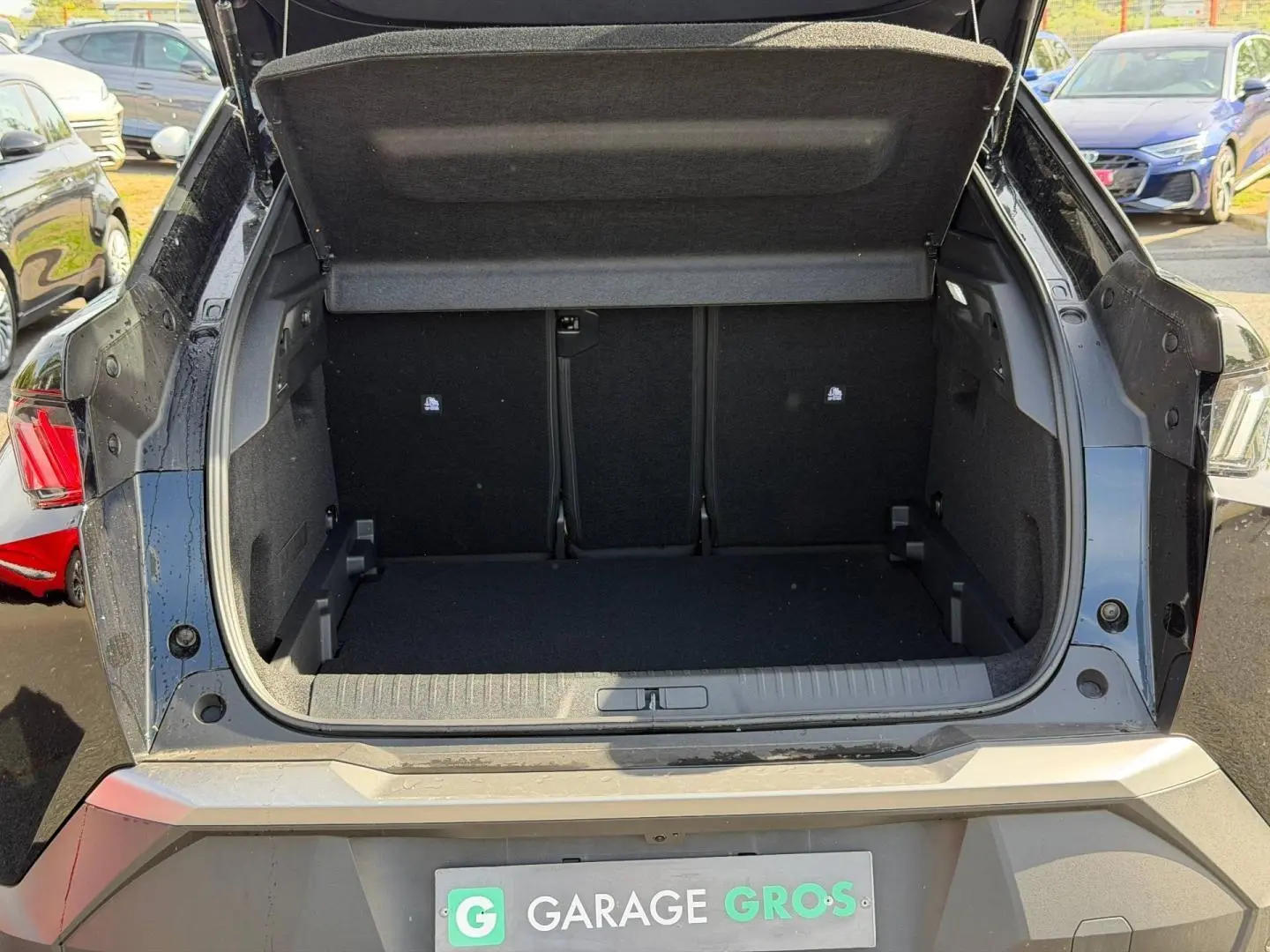 Coffre ouvert vu de l’arrière d’un Peugeot 3008 noir Perla Nera, montrant l’espace de chargement vide.