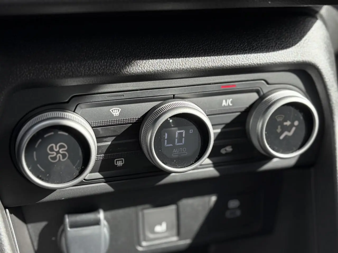 Gros plan sur les commandes de climatisation automatique du Dacia Jogger Gris Schiste, affichage digital au centre.