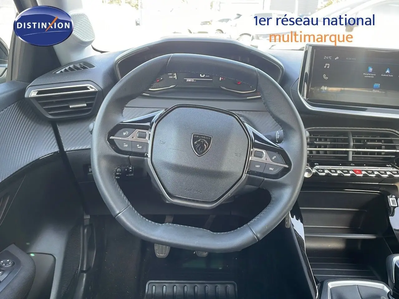 Vue intérieure centrée sur le volant Peugeot 208 2024, avec tableau de bord numérique et écran tactile moderne.