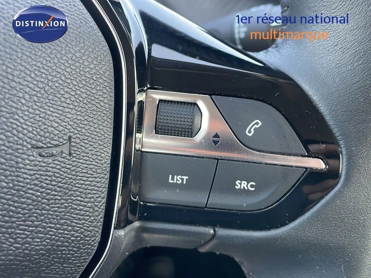 Gros plan sur les commandes au volant noir de la Peugeot 208 2024, avec boutons de gestion audio et appel.