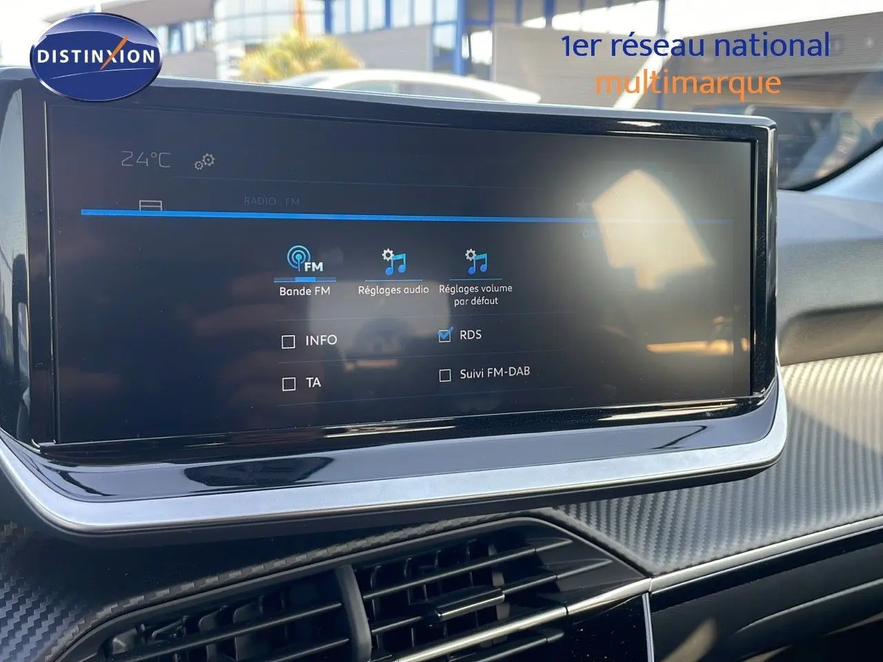 Écran tactile central affichant les réglages audio dans l’habitacle d’une Peugeot 208 blanc banquise 2024.