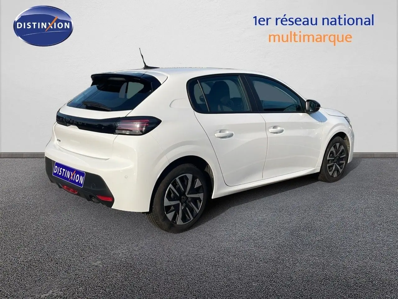 Vue 3/4 arrière droite d'une Peugeot 208 blanche Banquise 2024 avec feux arrière LED et jantes noires distinctives.