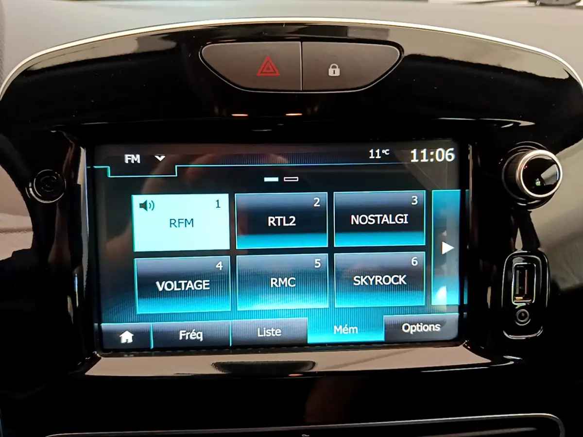 Écran tactile central de la Renault Clio Business TCe 90 2019 affichant les stations radio avec commandes autour en finition noire brillante.
