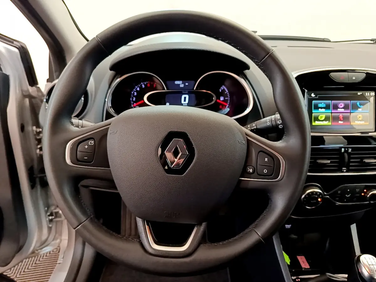 Vue rapprochée du volant en cuir noir d'une Renault Clio Business TCe 90 2019 avec tableau de bord et écran tactile visible.