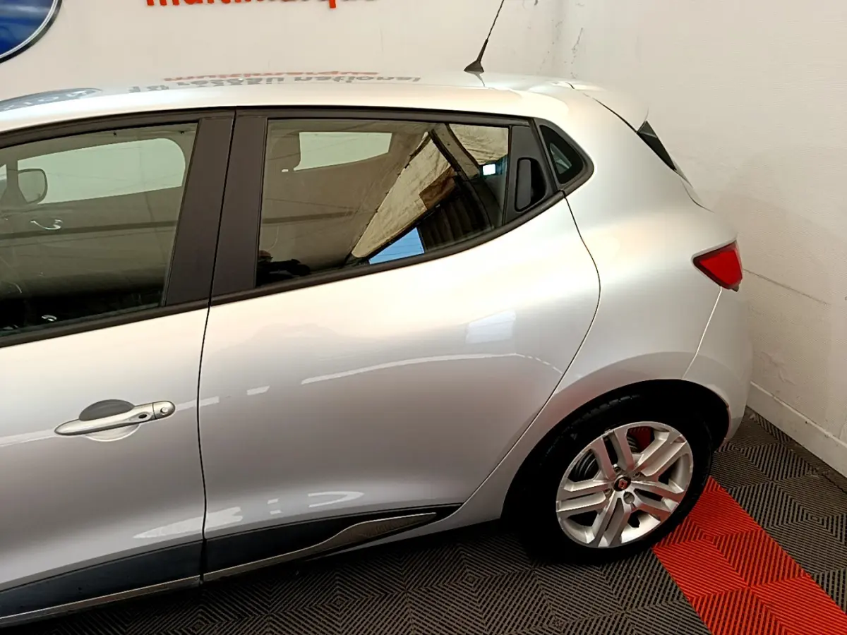 Profil côté droit d'une Renault Clio Business TCe 90 gris clair, mettant en valeur la ligne fluide et la jante alliage arrière.