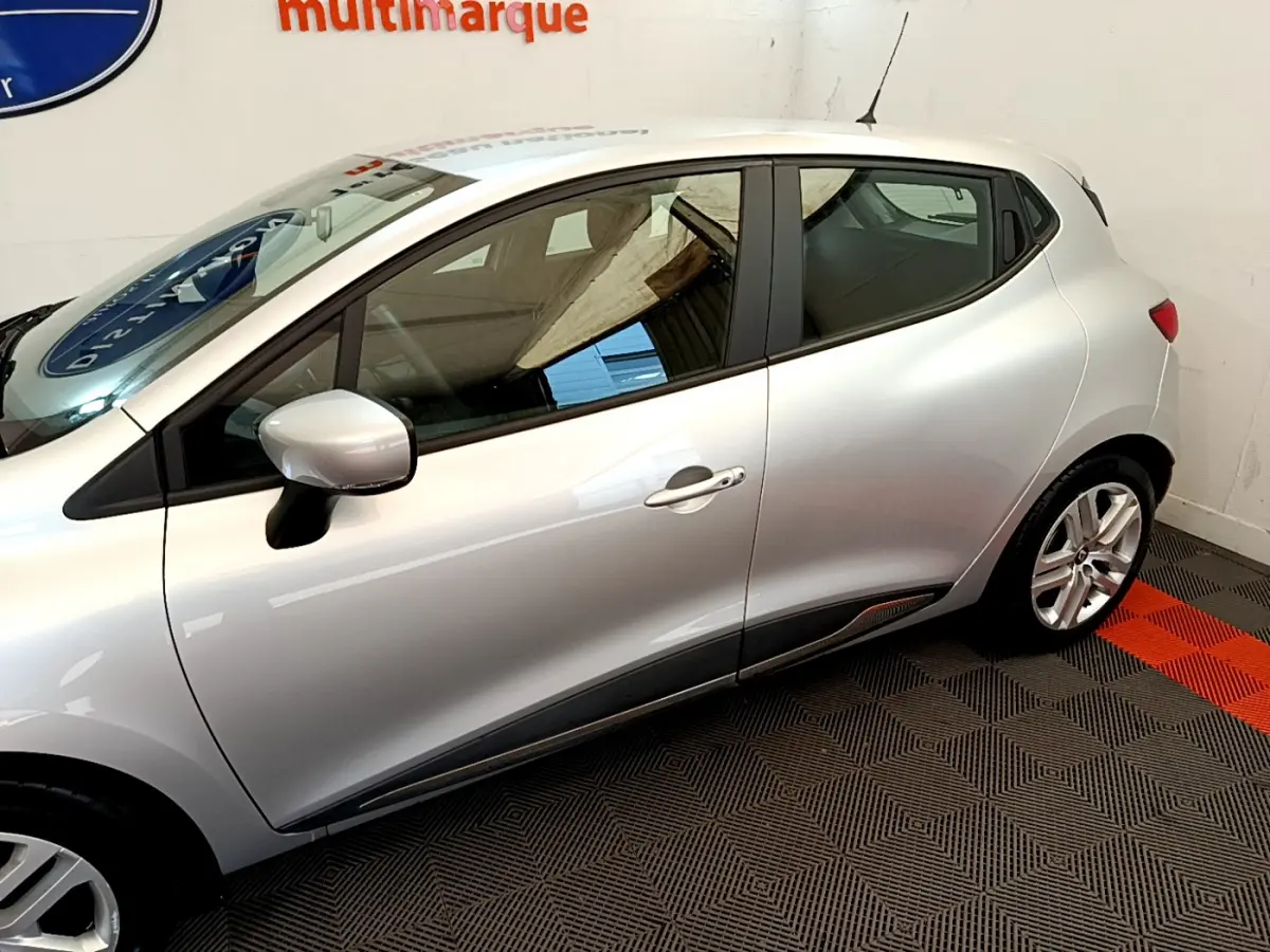 Profil côté gauche d'une Renault Clio Business TCe 90 gris clair, avec rétroviseur et jante alliage visibles.