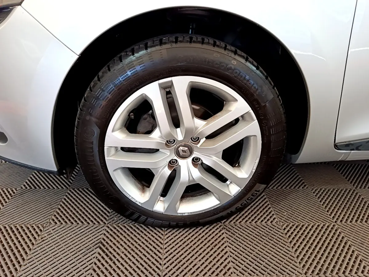 Gros plan sur la roue avant droite d'une Renault Clio Business TCe 90 gris clair avec jante alliage cinq branches.