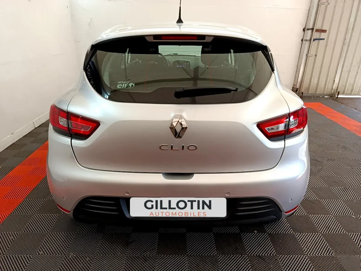 Vue arrière d'une Renault Clio Business TCe 90 gris clair stationnée sur un sol à damier noir et orange.