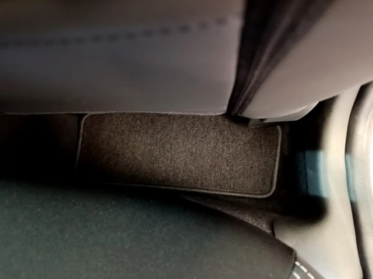 Détail du tapis de sol noir côté passager arrière d'une Renault Clio Business TCe 90 gris clair de 2019.