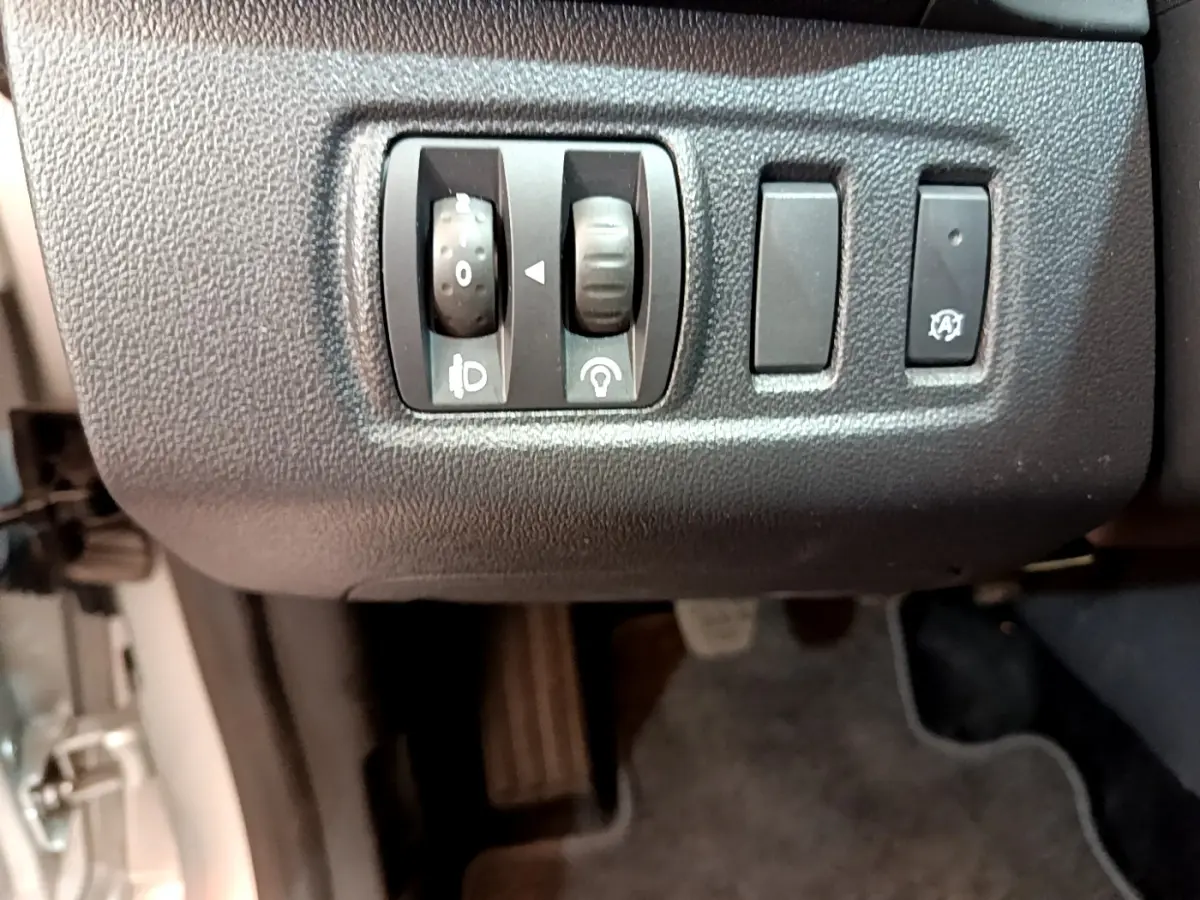Gros plan sur les commandes de réglage des phares et fonction arrêt automatique du moteur de la Renault Clio Business TCe 90 2019.