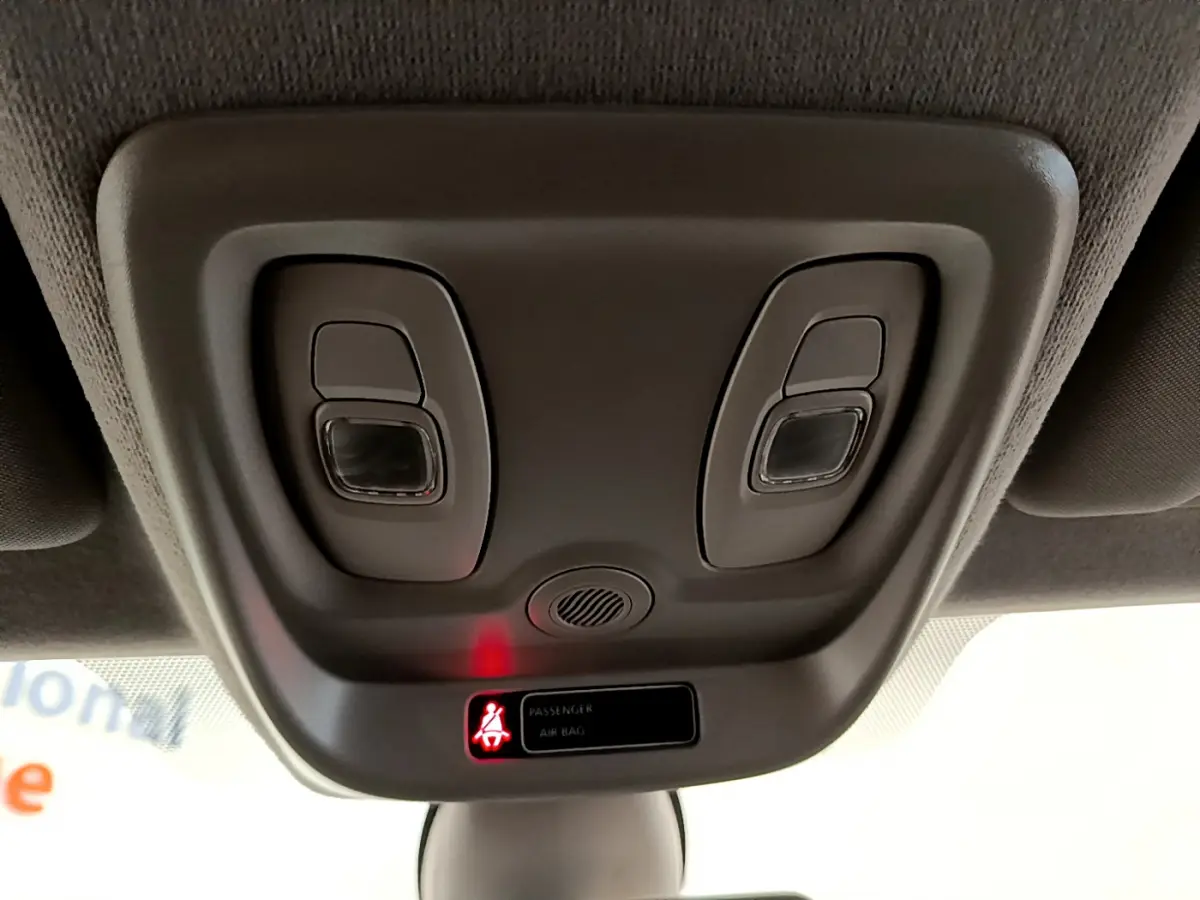 Gros plan sur la console de plafonnier gris clair de la Renault Clio Business TCe 90 avec témoin airbag passager allumé.